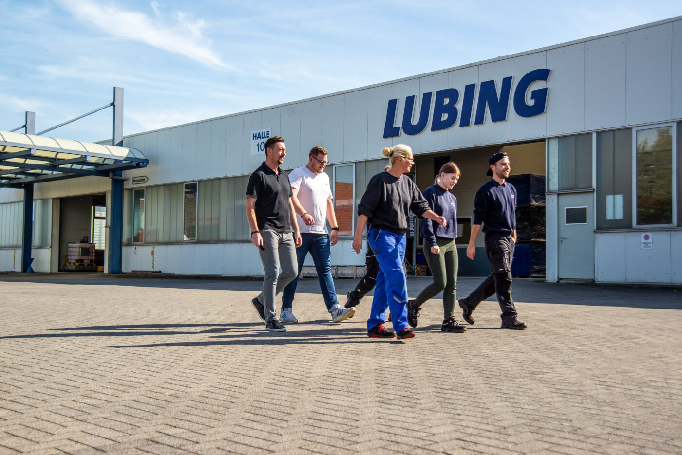 Team aus sechs Mitarbeitenden läuft über das Firmengelände